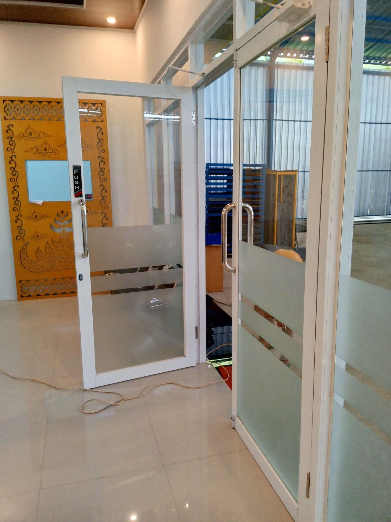Hasil pemasangan partisi aluminium kaca dengan pintu swing dan stiker sandblast